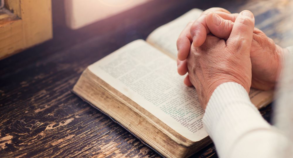 Praying with Bible - shutterstock